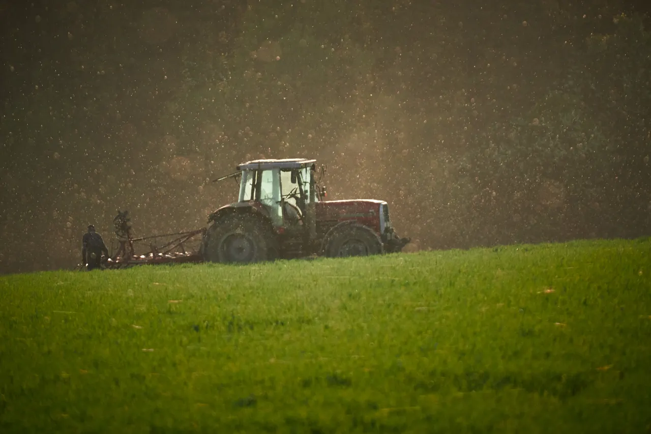 A tractor working across a cultivated field